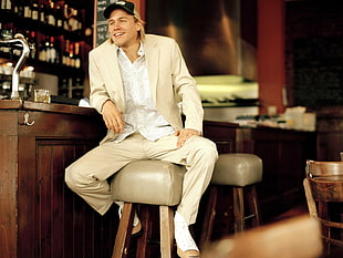 man in white suit sitting in the bar counter